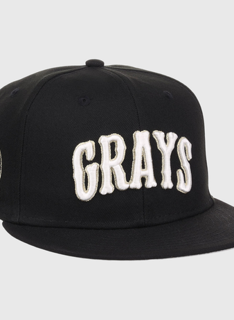 The EFF Homestead Grays Josh Gibson Fitted Ballcap in black features bold white GRAYS lettering on the front and a small embroidered portrait patch with text on the left side.