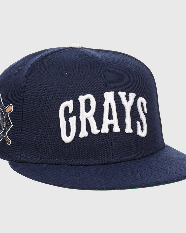 The EFF Homestead Grays NLB Flip Fitted Ballcap is a navy blue cap with GRAYS in bold white letters and a crossed bats “G” emblem, honoring the legendary Pittsburgh Homestead Grays.