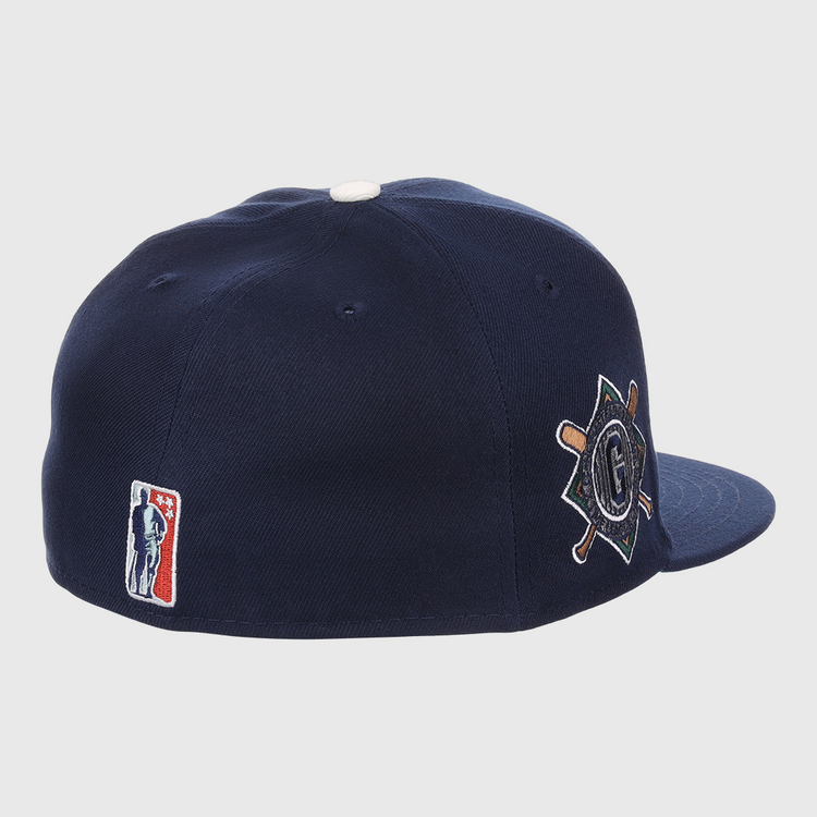 The EFF Homestead Grays NLB Flip Fitted Ballcap features dark blue fabric, a white top button, the classic MLB logo at the back, and a side patch with crossed bats and a “G” honoring Pittsburgh’s legendary Negro League team.