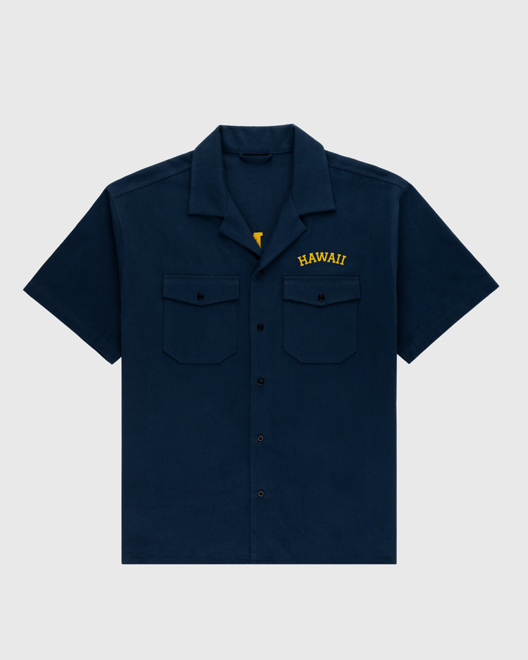 The Ebbets Field Hawaii Islanders (PCL) Cotton Linen Grounds Crew Short Sleeve Workshirt in navy features two chest pockets and HAWAII embroidered in yellow above the left pocket, shown on a plain light gray background.