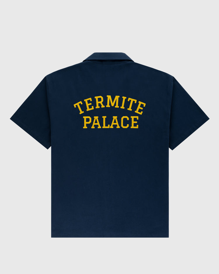 The Ebbets Field Hawaii Islanders (PCL) Cotton Linen Grounds Crew Short Sleeve Workshirt in navy features TERMITE PALACE in bold yellow on the back. Made from a cotton-linen blend, its shown laid flat on a light gray background.