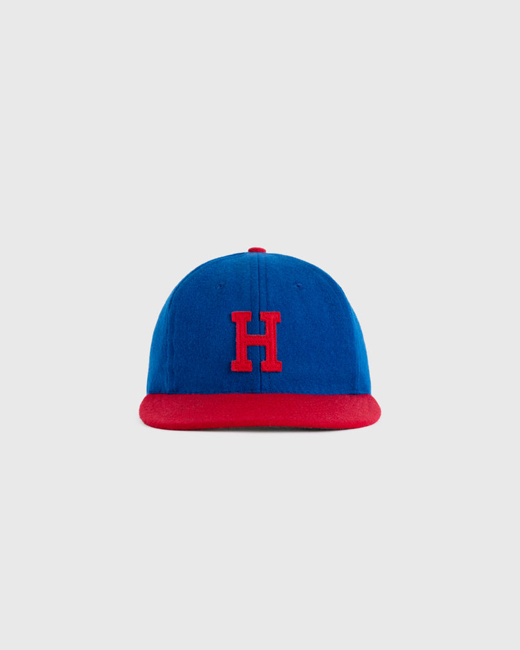 The EFF Hollywood Stars 1949 Authentic Wool Ballcap features blue wool, a red brim, and a red embroidered H, celebrating the Pacific Coast League team—shown here against a plain light gray background.