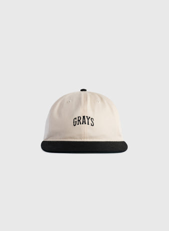The Ebbets Field Flannels Homestead Grays Embroidered Two Tone Cotton Twill Ballcap features a beige crown, black brim, and GRAYS embroidered in black on the front, inspired by the iconic Homestead Grays ballcap.