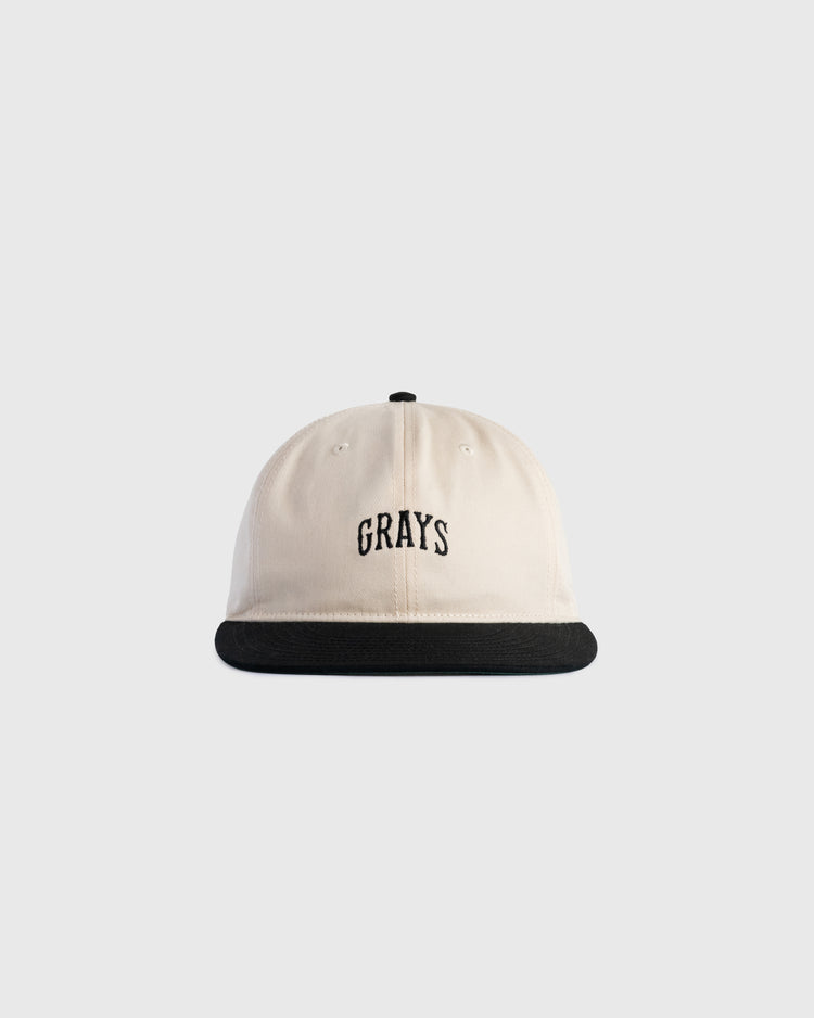 The Ebbets Field Flannels Homestead Grays Embroidered Two Tone Cotton Twill Ballcap features a beige crown, black brim, and GRAYS embroidered in black on the front, inspired by the iconic Homestead Grays ballcap.
