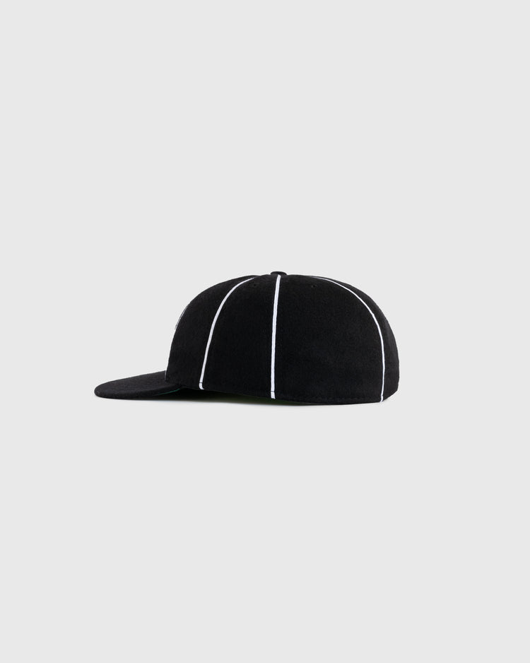 The EFF Homestead Grays 1939 Authentic Wool 8-Panel Ballcap features a black design with a flat brim and white vertical piping, honoring the legacy of Negro Leagues baseball, shown on a plain light gray background.