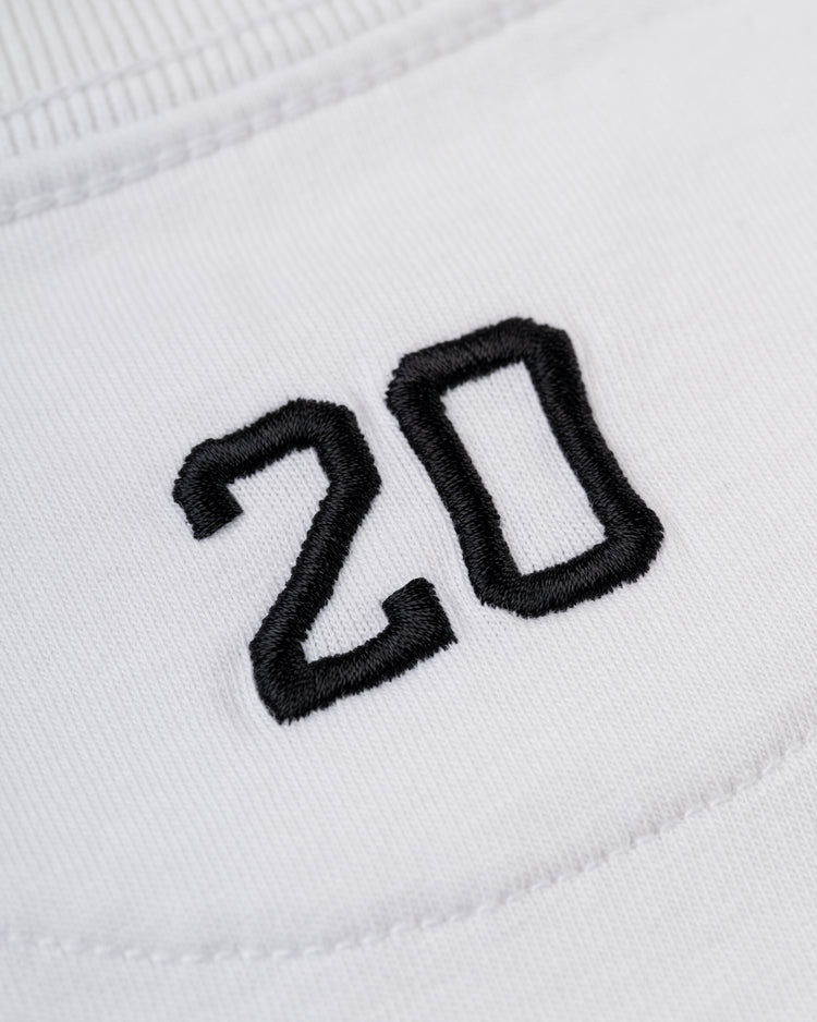 Close-up of the number 20 embroidered in black thread on white fabric, featured on the Ebbets Field Flannels Homestead Grays Embroidered G Short Sleeve Tee.