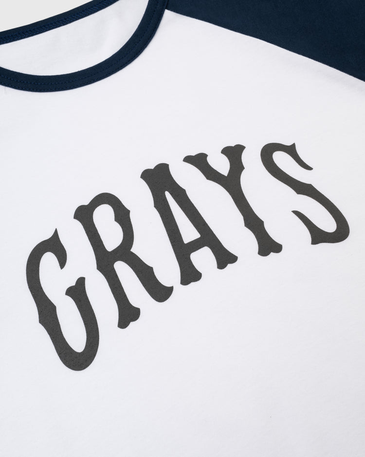 The Homestead Grays Vintage Baseball Tee by Ebbets Field Flannels features white fabric, dark blue edging and sleeves, and bold black GRAYS lettering—a classic design inspired by the Negro Leagues Baseball Museum.