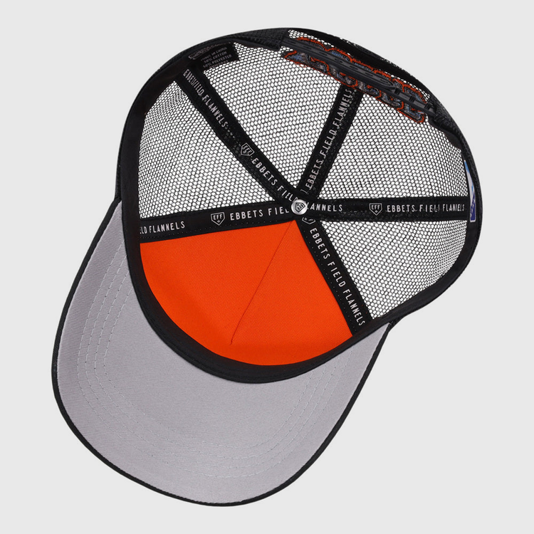 The underside of the Inland Empire 66Ers MiLB Trucker Ballcap by Ebbets Field is shown, displaying the mesh panels, interior structure, gray bill, and black fabric strips labeled EBBETS FIELD FLANNELS.