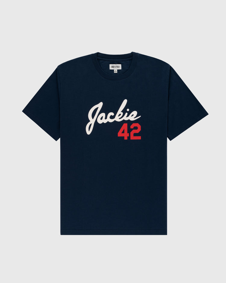 The Jackie Robinson Script 42 Short Sleeve Tee by Ebbets Field features navy blue fabric, Jackie in white script, and a red 42 on the front—a tribute to the Brooklyn Dodgers legend. Includes a crew neck and short sleeves.