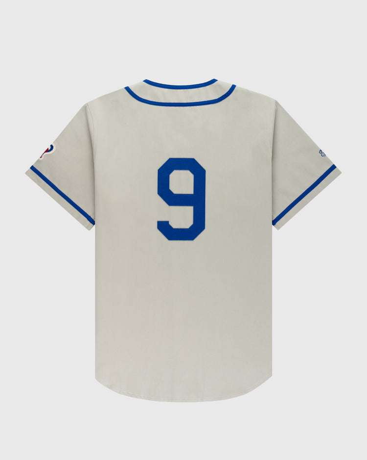 The Ebbets Field Montreal Royals Cotton Twill Baseball Jersey features gray cotton twill, short sleeves, blue trim, a bold blue number 9 on the back, and a small right sleeve logo inspired by Jackie Robinson’s classic jersey.