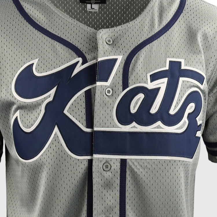 Close-up of the Kansas City Katz EFF DNA Replica Button-Up Mesh Jersey by EFF, featuring gray mesh with navy trim, buttons, and bold Kats script—a tribute to Kansas Citys historic Katz Drugstore and Ban Johnson Baseball League.