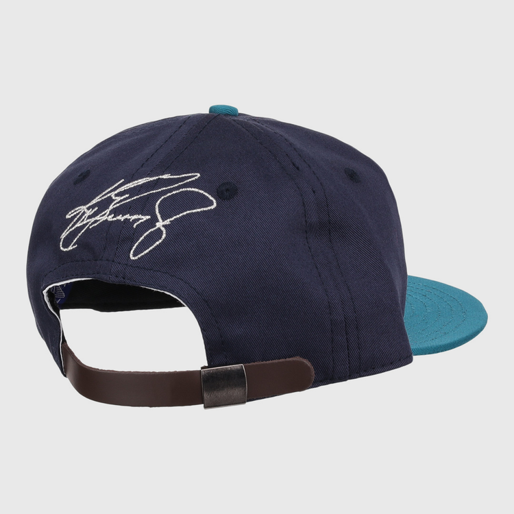 The Ken Griffey Jr. 1995 Signature Series Ballcap by Ebbets Field Flannels, shown from the back in navy blue and teal wool, features an adjustable brown strap and a white embroidered signature above the opening.