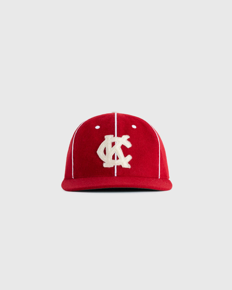 The EFF Kansas City Monarchs 1949 Authentic Wool Ballcap features red wool, white vertical piping, and a bold KC logo, inspired by the iconic 1949 team, shown here on a plain light gray background.