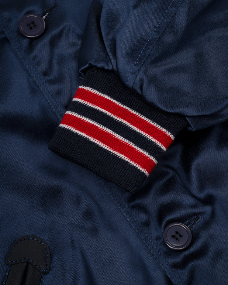 Close-up of the EFF Kansas City Athletics 1960 Authentic All Satin Varsity Jacket in shiny navy blue, with dark buttons and a ribbed cuff featuring red, white, and navy stripes.