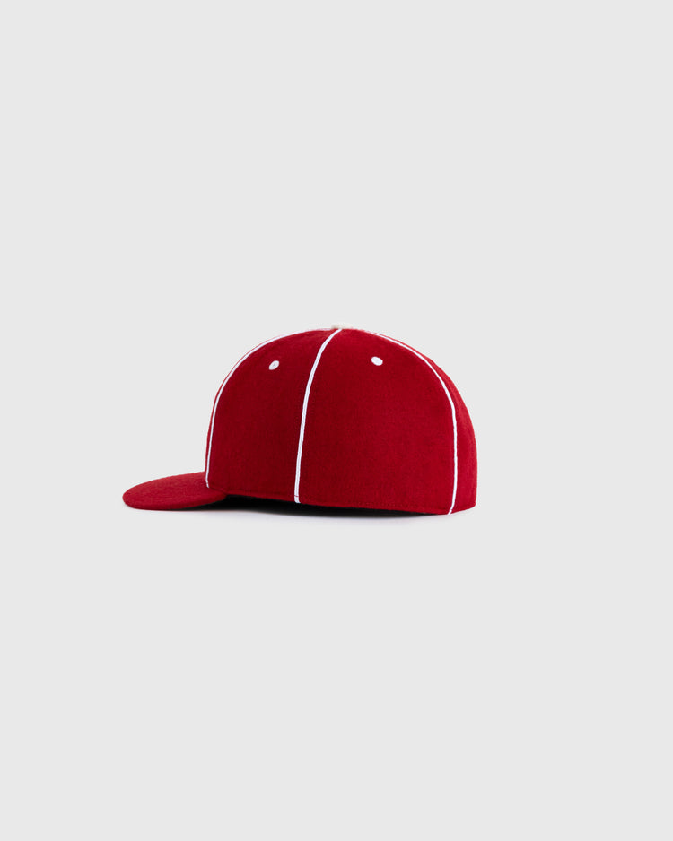 The EFF Kansas City Monarchs 1949 Authentic Wool Ballcap, in red with white piping, is shown from the side on a plain light gray background.