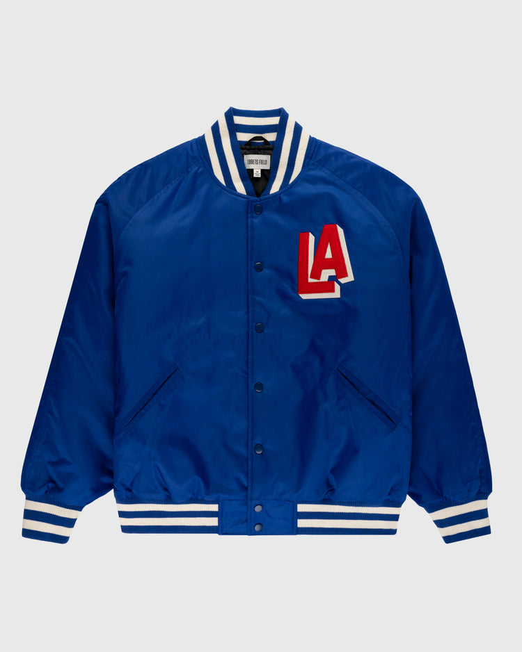 The Ebbets Field Los Angeles Angels (PCL) Satin Varsity Jacket features royal blue satin, white and blue striped cuffs, collar, and hem, snap buttons, and a bold red and white LA chest patch inspired by classic Angels jackets.