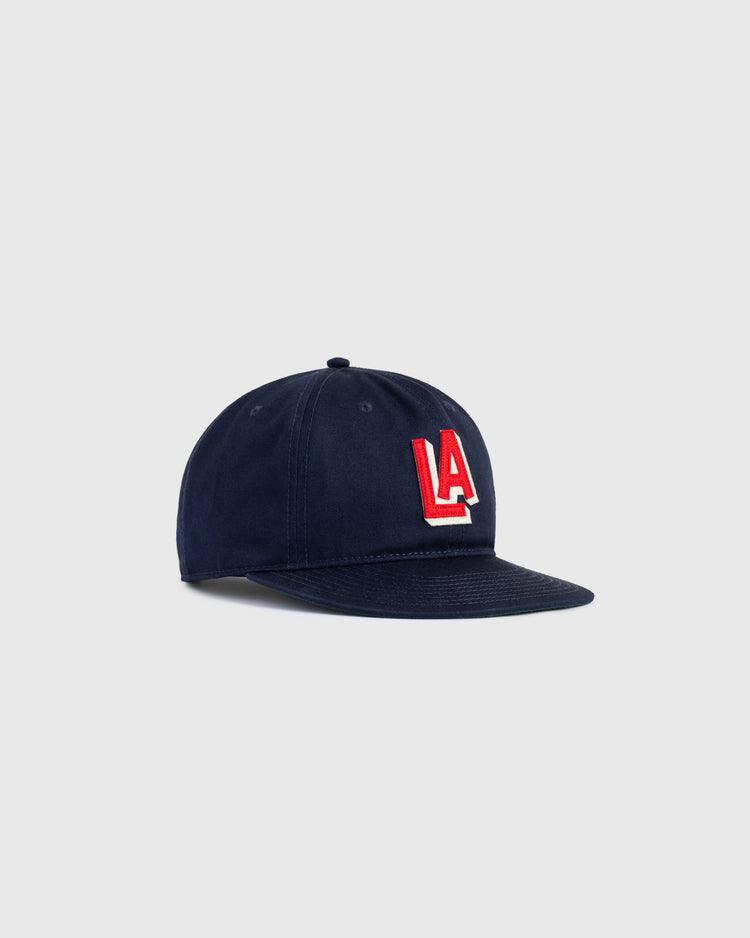 The Ebbets Field Los Angeles Angels (PCL) 1942 Logo Cotton Twill Ballcap features bold red and white LA letters on dark blue, vintage minor league style, shown on a plain light gray background.