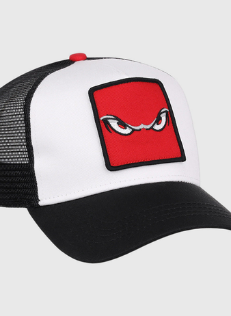 The Ebbets Field Lake Elsinore Storm MiLB Trucker Ballcap features a white front, black mesh back, and black curved brim with a red square patch displaying stylized, angry eyes embroidered on the front.