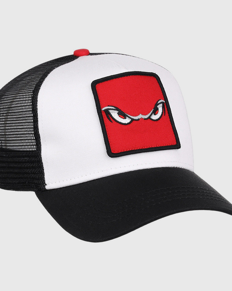 The Ebbets Field Lake Elsinore Storm MiLB Trucker Ballcap features a white front, black mesh back, and black curved brim with a red square patch displaying stylized, angry eyes embroidered on the front.