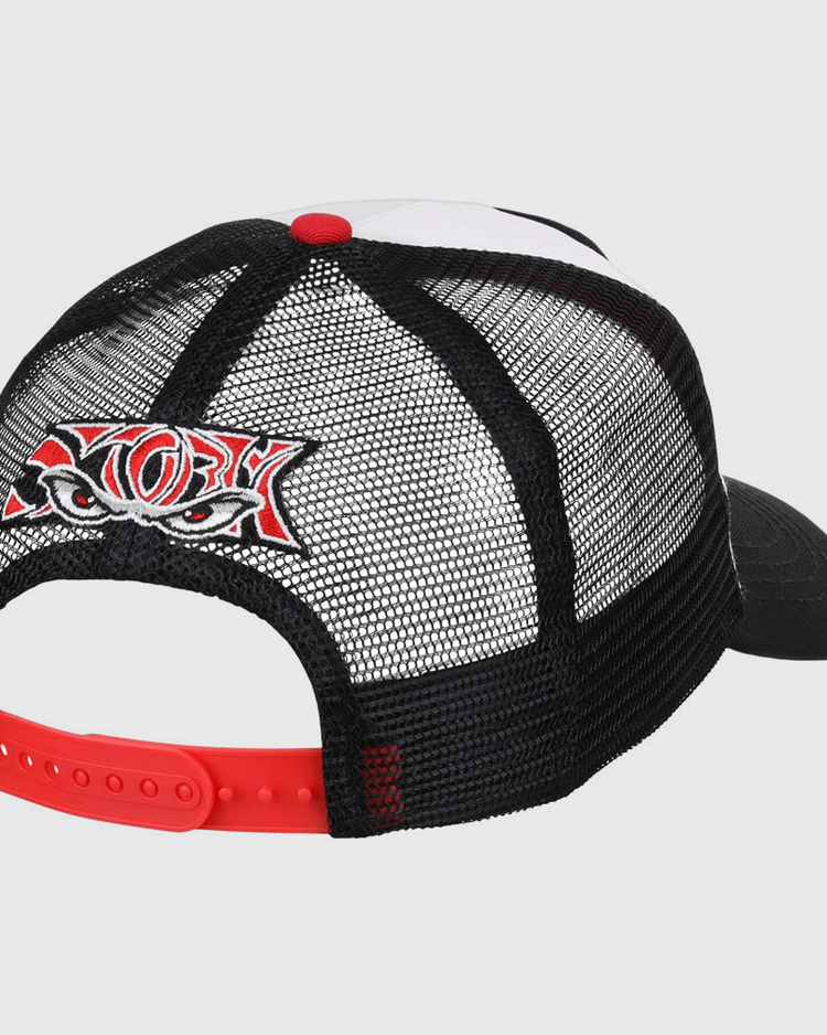 The Lake Elsinore Storm MiLB Trucker Ballcap by Ebbets Field is a black mesh hat with a red adjustable strap and a colorful embroidered patch of stylized eyes and bold lettering on the back. The front and bill are partially visible.