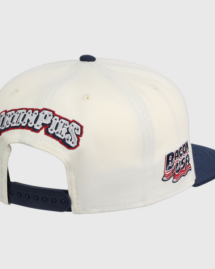 The Ebbets Field Lehigh Valley Ironpigs MiLB Snapback Ballcap is a white cap with a navy brim and adjustable strap, plus embroidered 