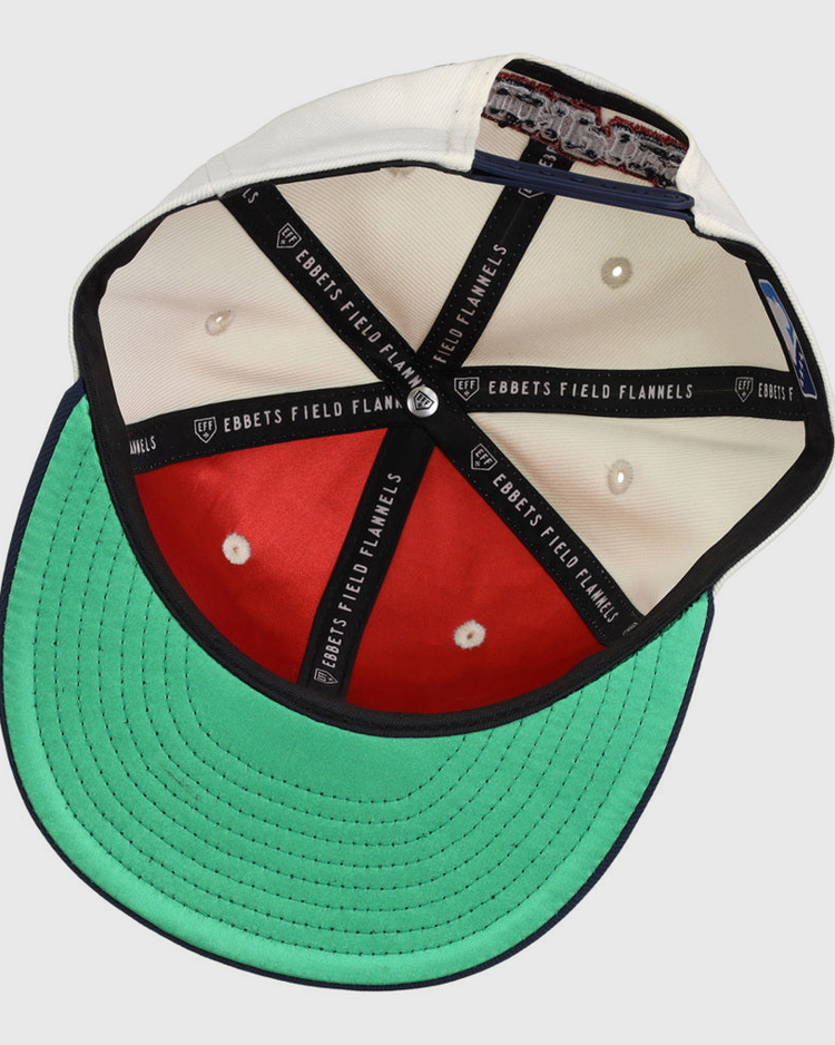 The inside of the Lehigh Valley Ironpigs MiLB Snapback Ballcap by Ebbets Field shows white and red panels, a green underbill, black taping with EBBETS FIELD FLANNELS text, and a cloth tag sewn into the sweatband.