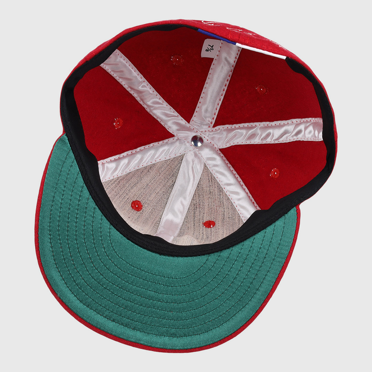 Top view inside the Lou Brock Signature Series Ballcap by Ebbets Field Flannels, featuring a green underbrim, white inner seams, red stitching, and a small size tag near the back.