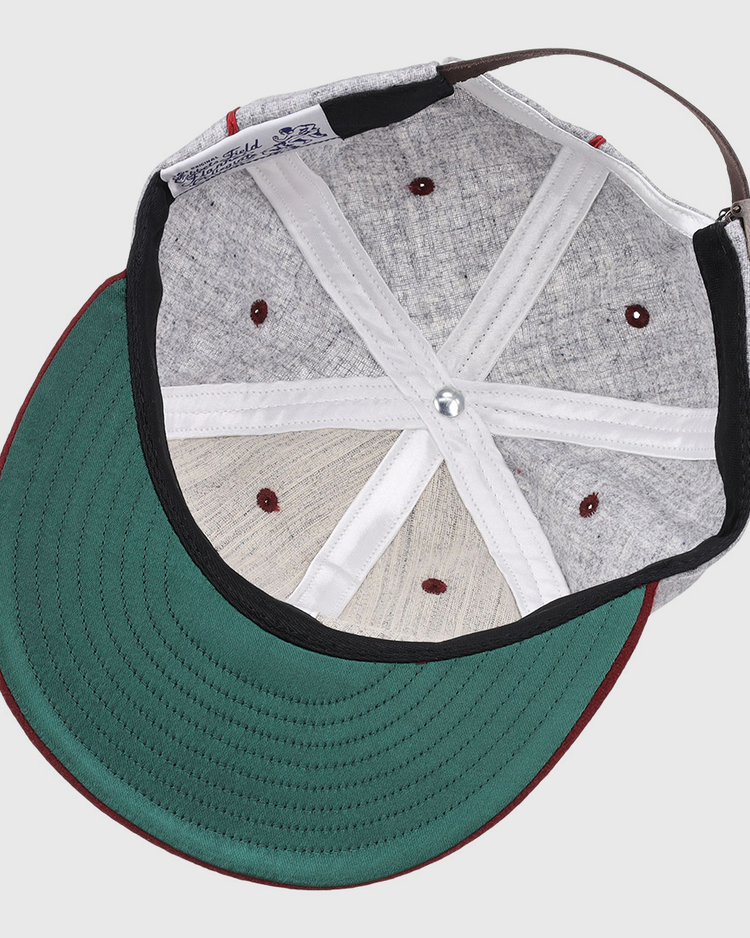 A look inside the EFF Loyola Marymount University 1939 Vintage Ballcap shows its green underbrim, red stitching, adjustable brown strap, visible internal seams, and ventilation holes—classic features of this historic hat.