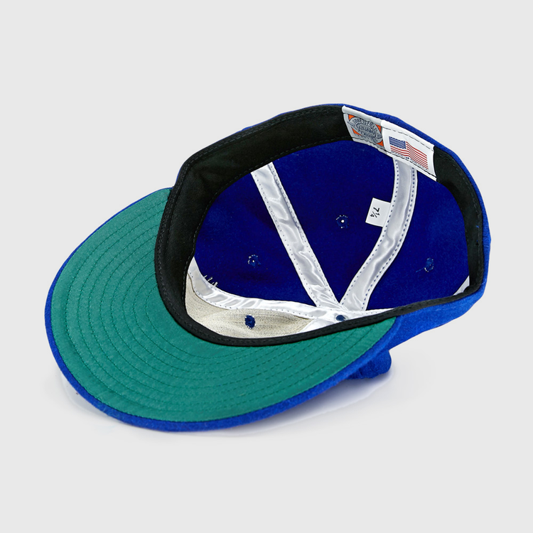 The EFF Memphis Red Sox 1944 Vintage Ballcap is shown upside down, revealing its green brim underside, black band, white interior labels, silver lining, and an American flag tag—just like the classic Negro American League style.