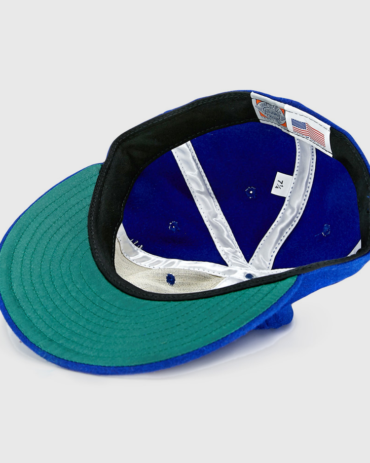 The EFF Memphis Red Sox 1944 Vintage Ballcap is shown upside down, revealing its green brim underside, black band, white interior labels, silver lining, and an American flag tag—just like the classic Negro American League style.