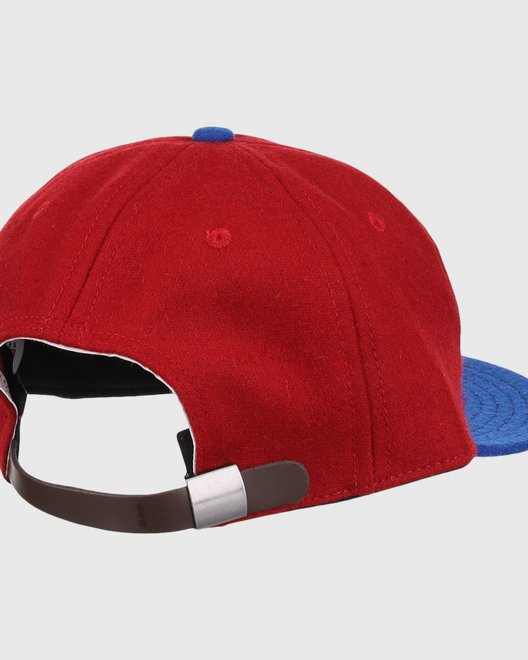 The Memphis Red Sox 1946 Vintage Ballcap by EFF features red and blue wool, a brown adjustable strap with a silver buckle, and classic details inspired by Negro American League styles.