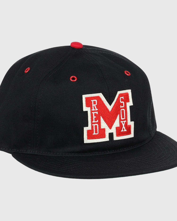 The EFF Memphis Red Sox Cotton Twill Ballcap is a black cap with a red button and eyelets, featuring a bold red M and Red Sox in white—honoring the legendary Negro American League team.