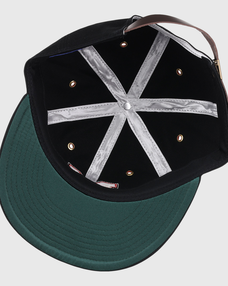 The image shows the inside of an EFF Memphis Red Sox Cotton Twill Ballcap featuring a black crown, green brim, silver lining strips, metal eyelets, and a brown adjustable strap—classic vintage details from Negro American League caps.