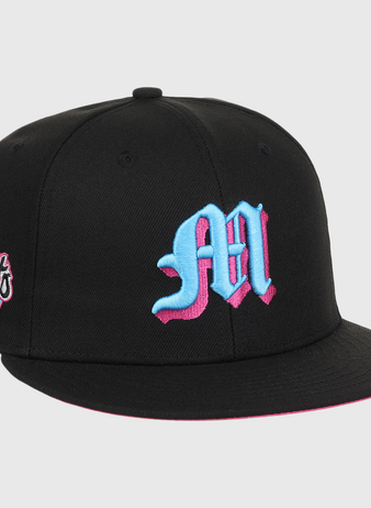 The EFF Miami Giants NLB Team Color Fitted Ballcap is a vintage-inspired black cap with a bold blue and pink M on the front and a matching embroidered San Francisco Giants team logo patch on the side.