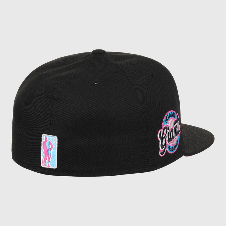 The EFF Miami Giants NLB Team Color Fitted Ballcap in black features a back view, an embroidered team logo patch, and a small pink and blue figure patch on the left, honoring this historic Black barnstorming team.