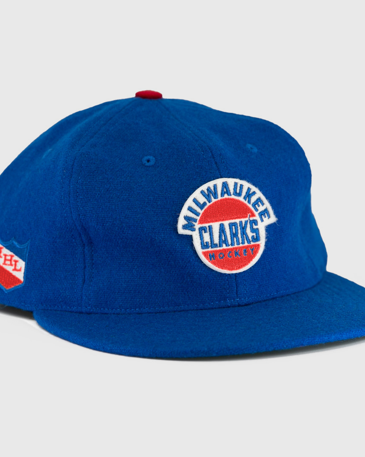 The EFF Milwaukee Clarks Vintage Ballcap is a blue wool cap with Milwaukee Clarks Hockey embroidered on the front and an IHL patch on the side—ideal for hockey fans and collectors.