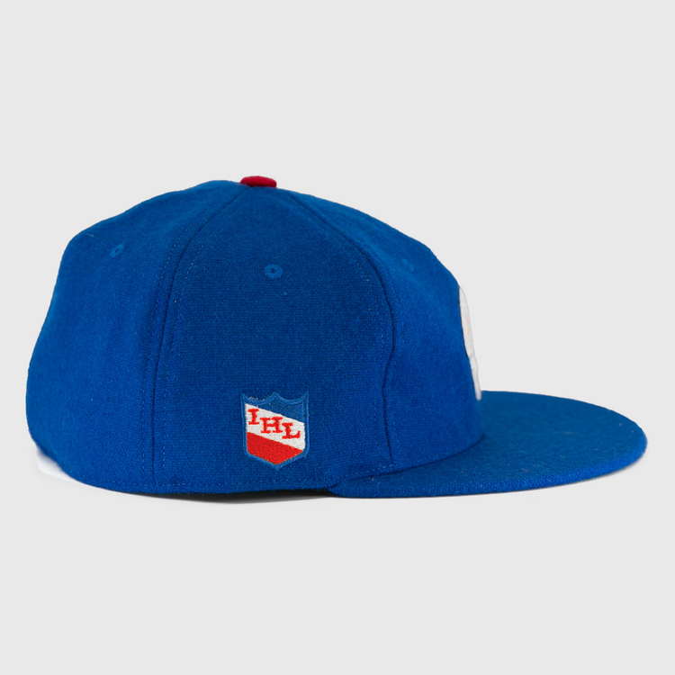 The Milwaukee Clarks Vintage Ballcap by EFF is a blue wool cap with a flat brim, featuring the International Hockey Leagues red and white shield logo on the side panel.