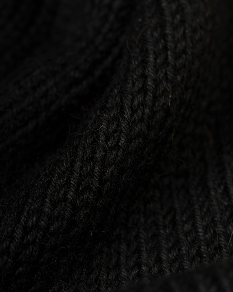Close-up of black knitted fabric with ribbed texture and detailed stitches, reflecting the vintage style of Ebbets Field Flannels Houston Colt .45s 1962-64 Wool Shawl Collar Sweater.
