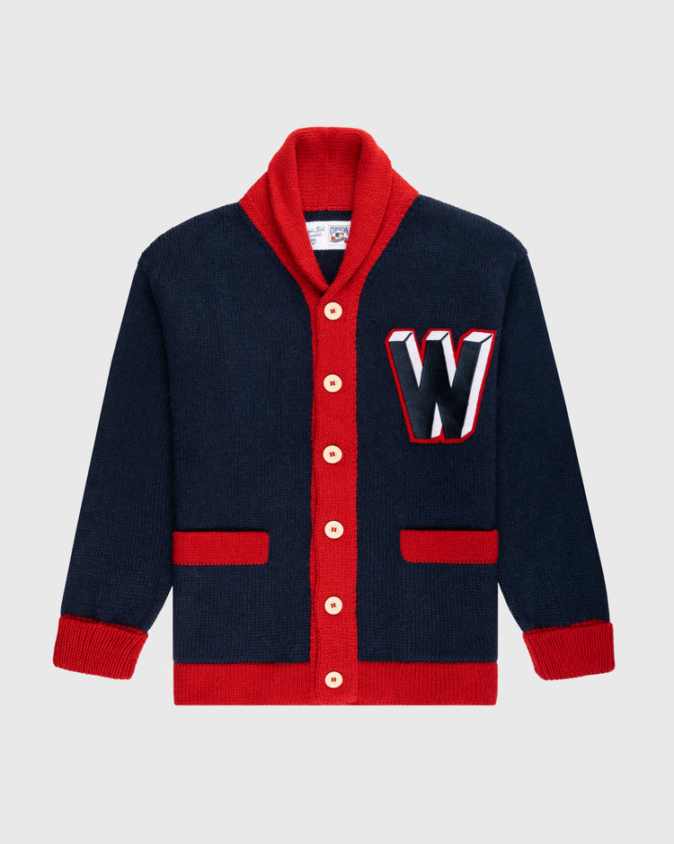 The Ebbets Field Flannels Washington Senators 1963-67 Wool Shawl Collar Sweater features navy wool, red trim and buttons, red pocket and cuff details, plus a large white, red, and black “W” patch—vintage on-field baseball style.