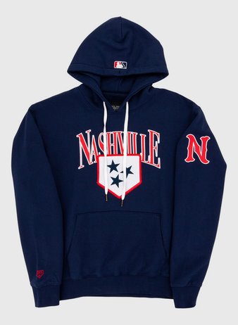 The Ebbets Field Nashville Sounds MiLB Cotton Hooded Sweatshirt is a navy blue hoodie with white drawstrings, Nashville in bold white and red letters, a three-star shield on the chest, red N on the sleeve, and an MLB logo on the hood.