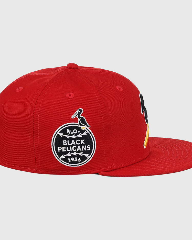 The EFF New Orleans Black Pelicans NLB Team Color Fitted Ballcap in red features embroidered patches, including a circular 1926 Negro Southern League logo with a black-and-yellow pelican on the front.