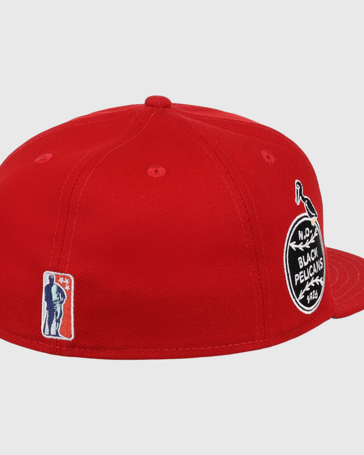The EFF New Orleans Black Pelicans NLB Team Color Fitted Ballcap in red features a round black-and-white side patch, an embroidered bat-wielding silhouette near the back, flat brim, visible stitching, and Negro Southern League heritage.