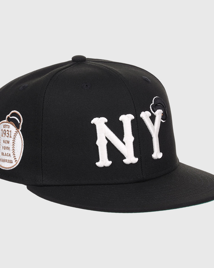 The EFF New York Black Yankees NLB Flip Fitted Ballcap features bold white NY letters, a black design, and a brown 1931 patch on the side honoring Negro National League heritage.