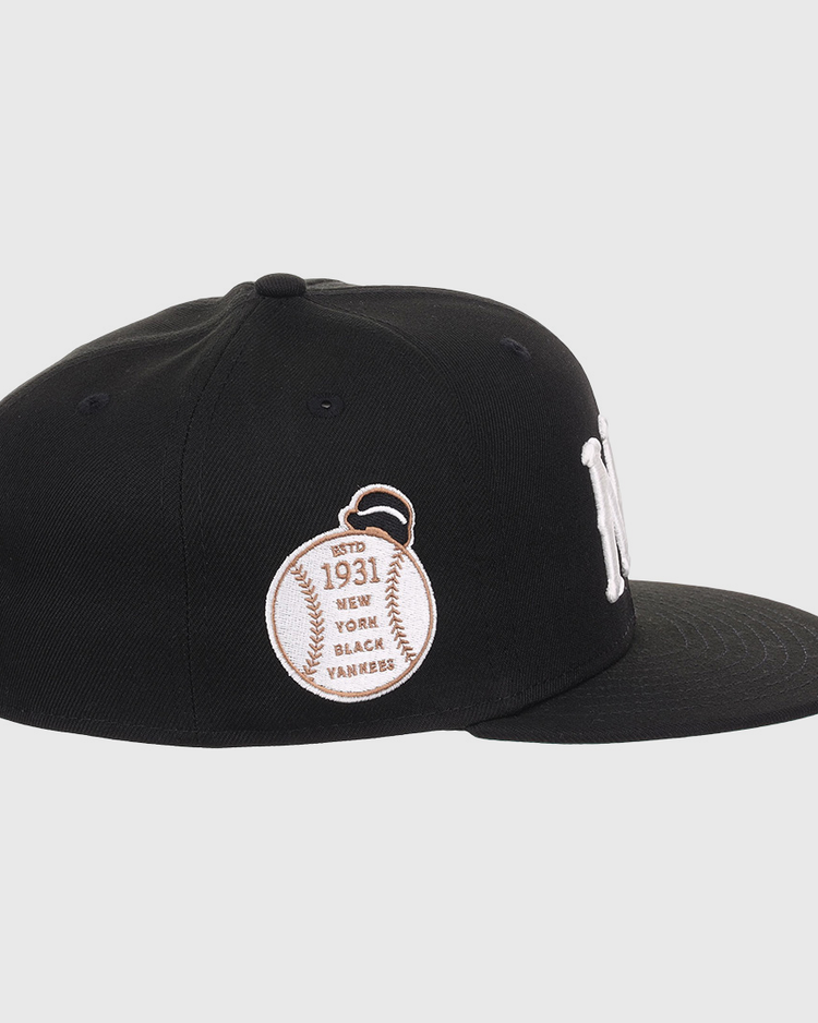 The EFF New York Black Yankees NLB Flip Fitted Ballcap is black with a white NY logo, a baseball patch reading Est. 1931, and New York Black Yankees embroidered on the side to honor the Negro National League. Flat brim design.