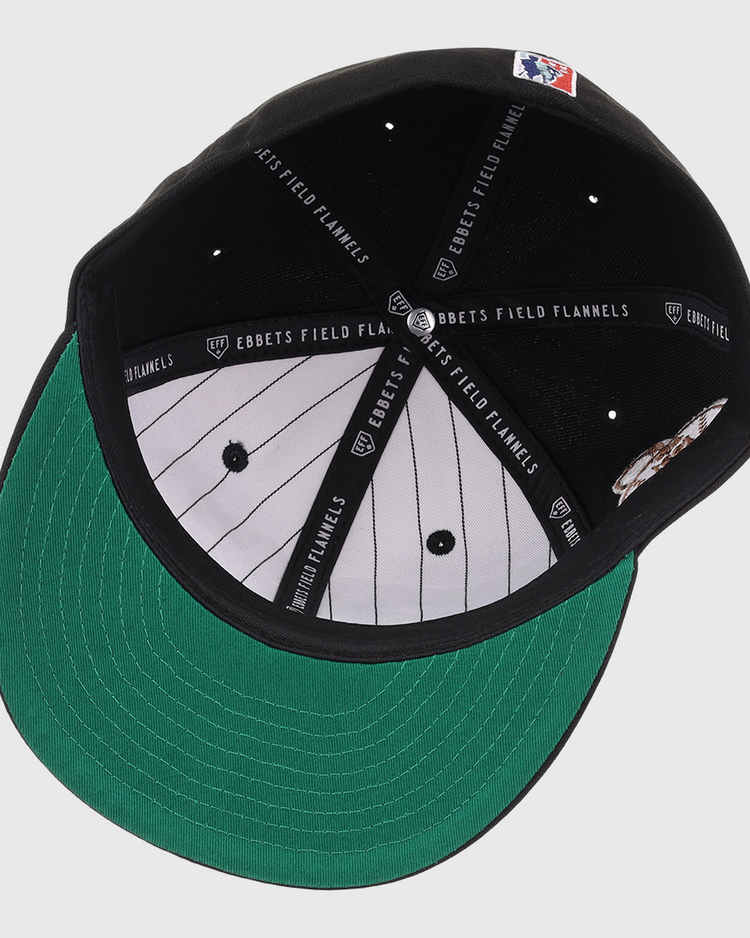 The New York Black Yankees NLB Flip Fitted Ballcap by EFF features a black crown, green brim, white pinstriped lining, and black bands labeled EBBETS FIELD FLANNELS. An MLB logo patch at the back honors the Negro National League legacy.