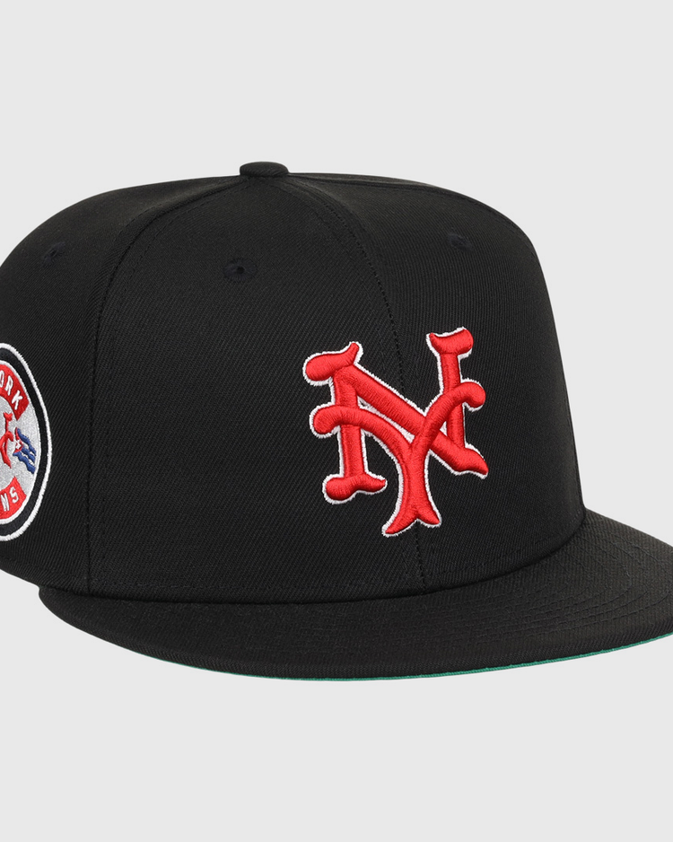 The EFF New York Cubans NLB Team Color Fitted Ballcap is a vintage-inspired black cap with a 3D red NY logo on the front and a round New York Giants patch on the side.