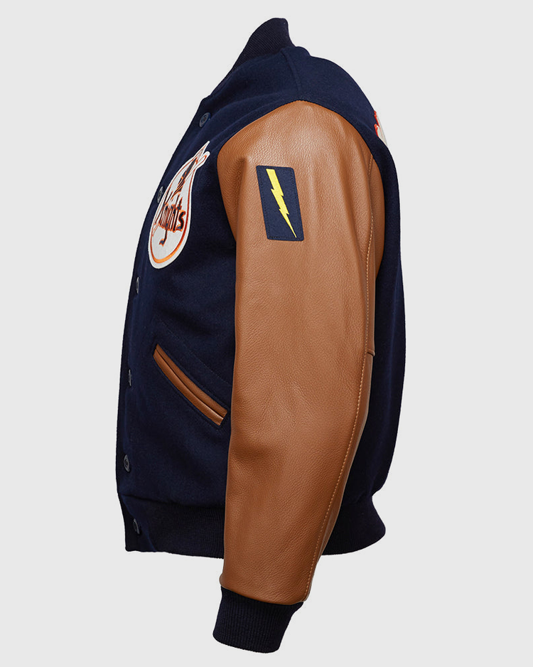 The EFF New York Knights 1939 Authentic Jacket is a navy melton wool varsity jacket with tan leather sleeves, a yellow lightning bolt patch on the upper arm, and a circular chest logo, shown from a side angle.