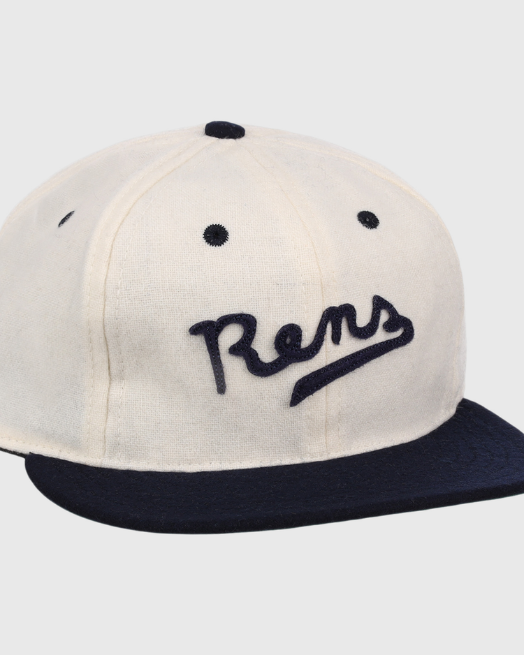 The New York Rens Wool Ballcap by Ebbets Field Flannels is a vintage-style white cap with a navy brim and Rens embroidered in script, celebrating Black basketball history and the legacy of the legendary team.