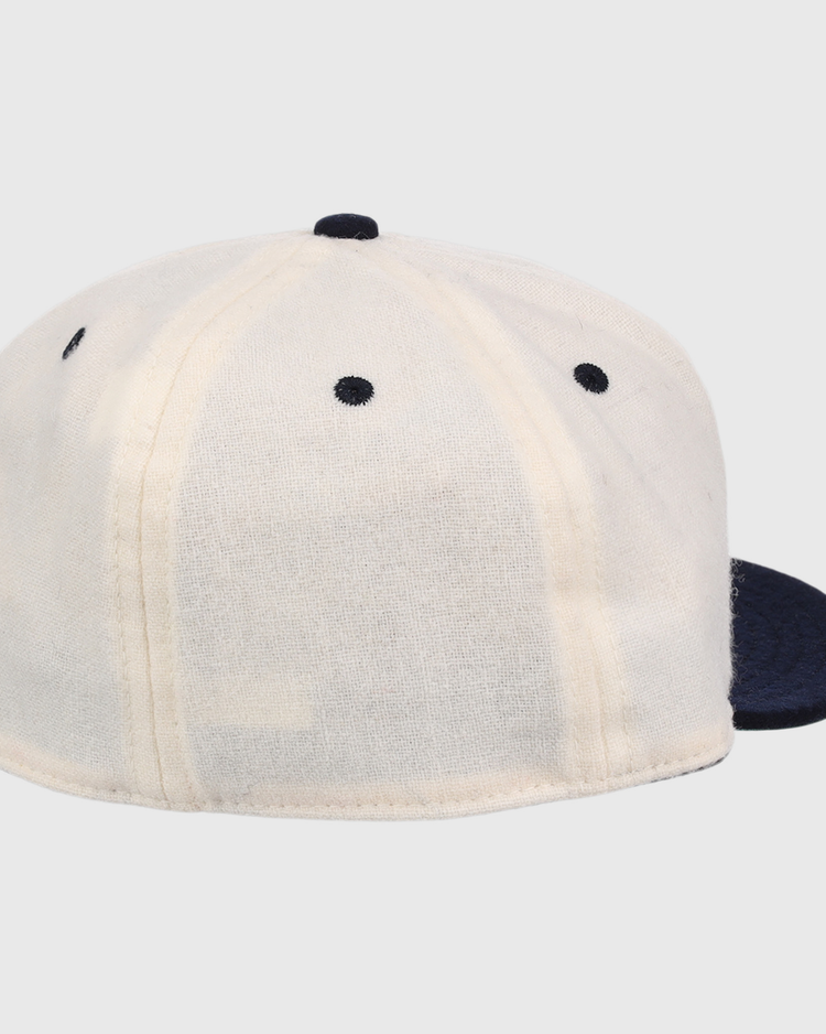 The Ebbets Field Flannels New York Rens Wool Ballcap features a dark navy brim, white panels with black stitching, vintage-inspired seams, and a round top button, shown from the back.