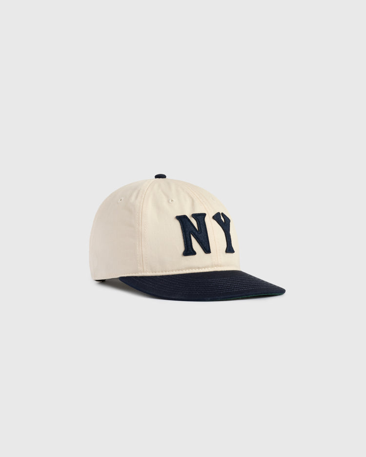 The Ebbets Field New York Black Yankees Felt NY Cotton Twill Ballcap features a beige crown, navy brim, and bold raised navy NY logo on the front, inspired by the classic Black Yankees cap, shown against a plain light background.